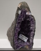 A geological rock or mineral specimen of an amethyst geode approx 55cm tall by 26cm wide