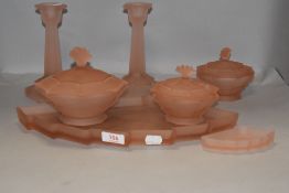 A 1930's style seven piece peach pressed glass dressing table set