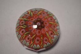 A glass paperweight, probably Scottish, with foliate and twisted canes. 7.5cm diameter.