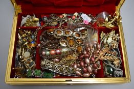 A jewellery case containing a selection of costume jewellery including brooches, cufflinks,