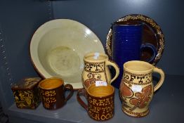 A selection of motto slip wares including a stone ware butter or cream bowl