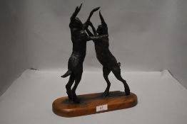 After Jon Bickley 'Boxing Hares' cast-bronzed resin group, bearing moulded signature, on a rounded