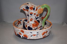 A reproduction 'Ironstone' toilet jug and bowl, the jug of hydra form, both decorated in an Imari