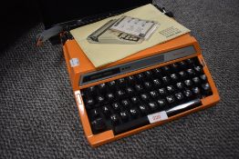 A classic mid century Silver Reed typewriter or Tabulator 250 in tangerine orange with case