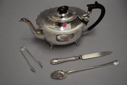 A silver plated tea pot having hard wood handle, frilled rim and paw feet, and three pieces of