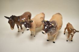 A Beswick Jersey cow family including bull calf and cow along with similar donkey