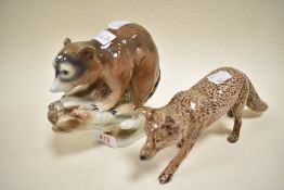 A Gerold Porzellan, Barvaria Racoon and a wolf in brown gloss marked Tom Mackie.