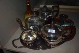 A silver plated part tea set with a serving tray and three pieces of Penrith pottery