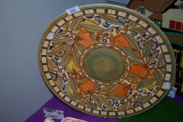 A large hand decorated ceramic charger plate by Charlotte Rhead for Bursley Ware