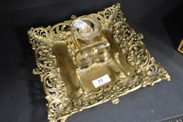 A Victorian cut glass inkwell with ornate brass tray having integrated quill rack.AF.