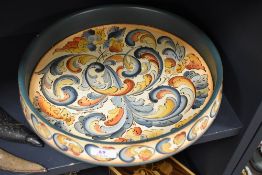 A large painted decorative wooden bowl having painted motifs in green and autumnal colours,marked