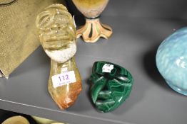 A carved and polished malachite sample, formed as a mask and sold together with an African stone