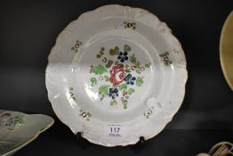 A 19th century hand decorated tin glaze plate, with foliate moulding to the rim.