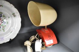 A retro Pifco desk lamp, with red plastic base and cream plastic shade, large surface clip to base.