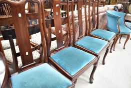 A set of four late Victorian mahogany framed dining chairs having slatted scroll backs