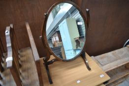 An early 20th Century mahogany toilet mirror having shaped frame