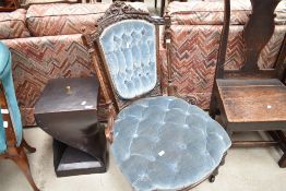 A mid Victorian nursing chair having ornate carved back with pillar supports