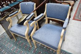 A pair of painted French style scroll armchairs