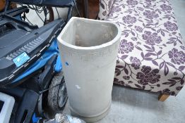 A cast composite stone corner planter with meandros border decoration.