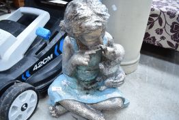 A cast resinous garden ornament, gilt with puppy, painted in silver and blue.