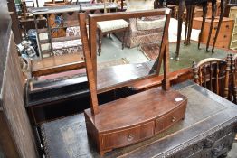 An early 20th century dressing table mirror having band fronted curved drawer base