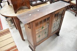 An Arts and Crafts bookcase top having lead glazed doors