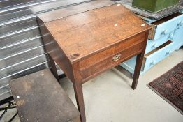 A 19th Century oak clerks or shop desk, having slope top with three internal and one frieze