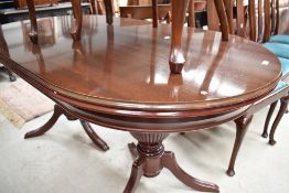 A modern mahogany dining table with twin pedestal base