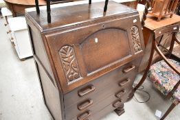 A 1940's oak bureau, of traditional design with trestle type feet to base