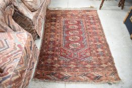 A small Turkish or Persian style rug in red grounds approx 2ft x 4 ft