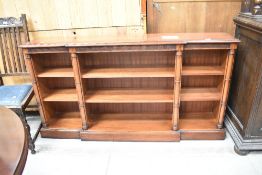 A modern mahogany long break front book case having pillar supports in a regency style