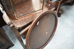 An early 20th Century oak folding occasional top having circular 'tray' top