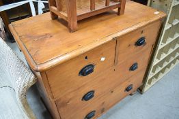 An early 20th century pine chest of 2/3 drawers, each with black painted metal handles, raised on