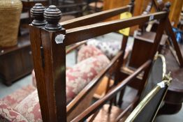 An Edwardian mahogany towel rail, square section with turned finials.