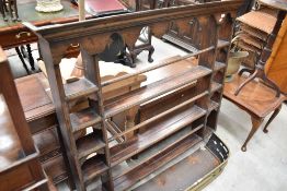 A George III oak plate rack, having a moulded cornice over shaped canopy and three open 'shelves'