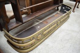 An Arts and Crafts brass fender, of rounded oblong form with pierced and moulded decoration.