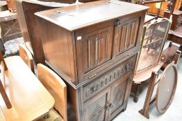 A 1980's oak linen-fold drinks cabinet, marked JC to reverse