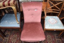 A Victorian nursing chair having later dralon pink upholstery, on turned leg and pot castors