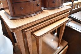 A golden oak nest of three tables