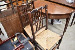 A pair of period style spindle back chairs having rush seats