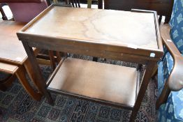 A traditional tea trolley having fold over games top lined with green beize