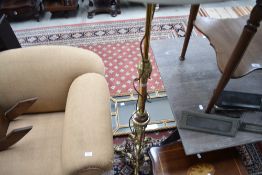 An ornate brass standard lamp having copper detailing