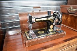 An Antique Singer sewing machine, hand crank, with typical dome top branded case