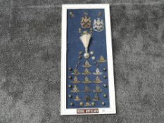 A framed display of Military Cap & Helmet Badges for the Royal Artillary including Helmet Plates for