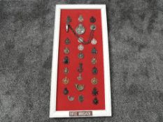 A framed display of Military Cap Badges for the Rifle Brigade including 1st North Riding Rifle