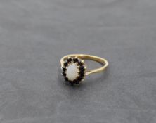 An opal and sapphire oval cluster dress ring in a claw set basket mount on a 9ct gold loop, size N &