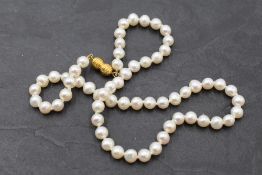 A short string of cultured pearls having yellow metal screw barrel clasp, approx 15'