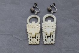 A pair of Chinese carved devil's work nephrite jade earrings having white metal screw back fittings