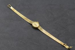 A lady's 14ct gold Geneve wrist watch having baton numeral dial to oval face in gold case with fixed