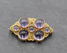 A yellow metal filigree brooch stamped 14K of lozenge form having seven Amethyst cabouchons,